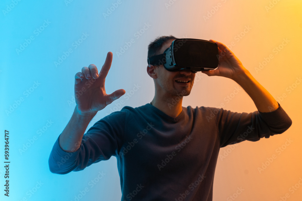 Fototapeta premium Virtual glasses gaming experience. Neon lighting. Young european man