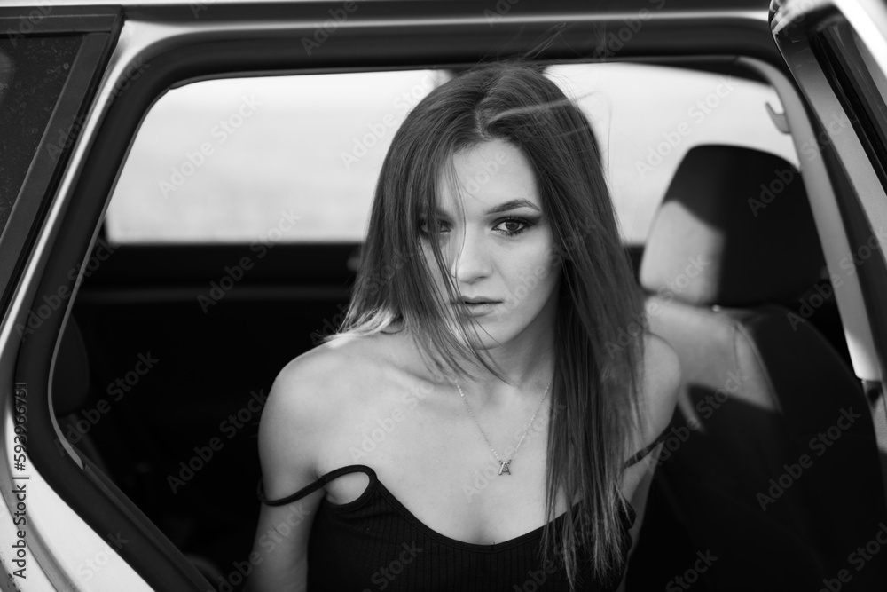 Closeup monochrome shot of the female sitting in the car with a serious face Closeup monochrome shot of the female sitting in the car with a serious face