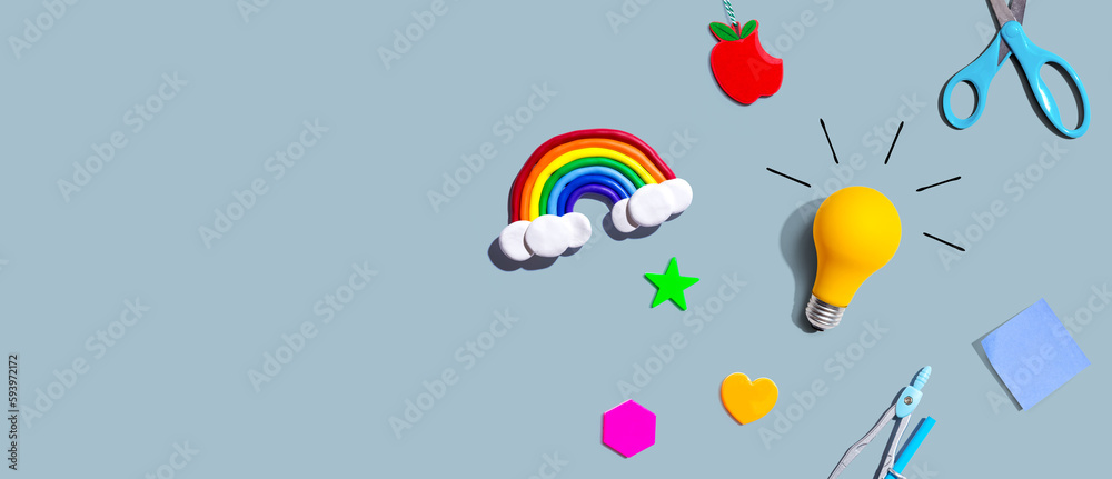 Idea light bulb with a rainbow and school supplies overhead view - flat lay