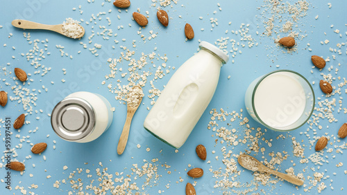 Milch Alternativen aus Mandel, Hafer und Reis in Glasflaschen auf einem blauen Tisch. Draufsicht.  photo