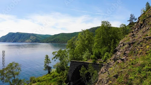 Beautiful summer landscape. An old  tunnel in a rock near the shore of Lake Baikal.  