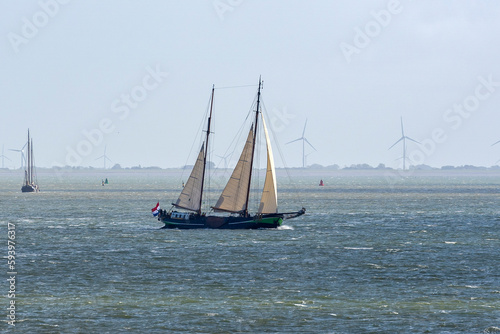 During a sunny but windy autumn day, several old sailing ships sail on the water of the Wadden Sea between Vlieland and the mainland near Harlingen, the Netherlands photo