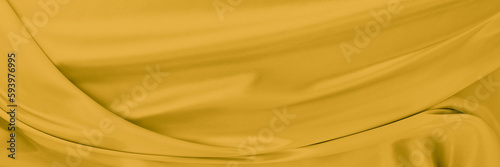yellow gold satin texture that is white silver fabric luxurious shiny that is abstract silk cloth background with patterns soft waves blur beautiful. © Kamjana