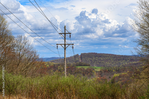 A power line in the field in Autumn in Upstate NY. Fire break with power lines cutting across the woods in the distance. 