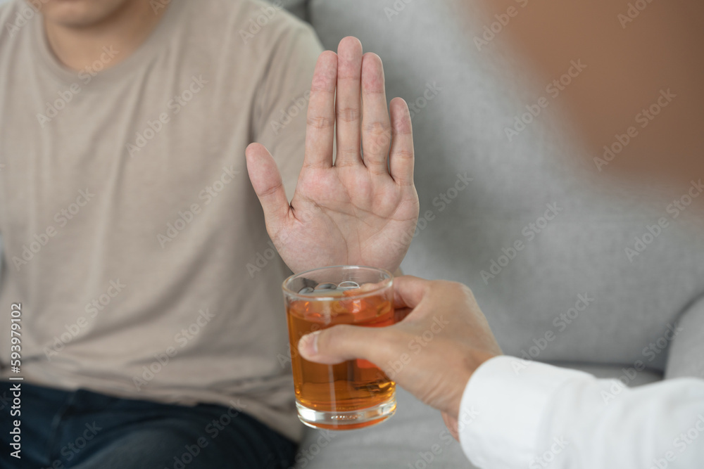 man refuses say no and avoid to drink an alcohol whiskey , stopping