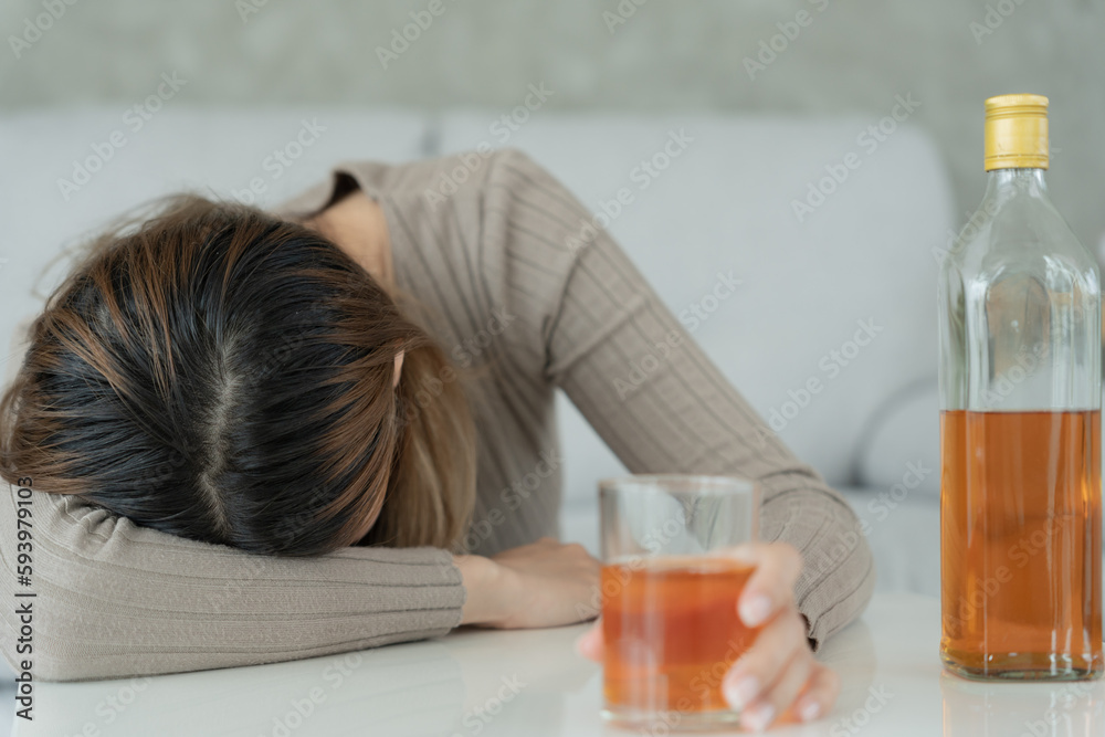 Depressed young Asian woman addicted feeling bad drinking whiskey alone at home, stressed frustrated lonely drinking alcohol suffers from problematic liquor, alcoholism, life and family problems Depressed young Asian woman addicted feeling bad drinking whiskey alone at home, stressed frustrated lonely drinking alcohol suffers from problematic liquor, alcoholism, life and family problems