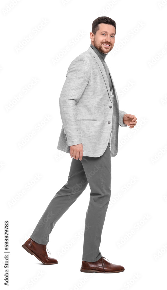 Handsome bearded businessman walking on white background
