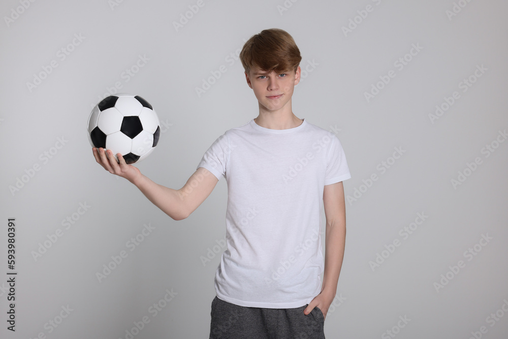 Teenage boy with soccer ball on light grey background Teenage boy with soccer ball on light grey background