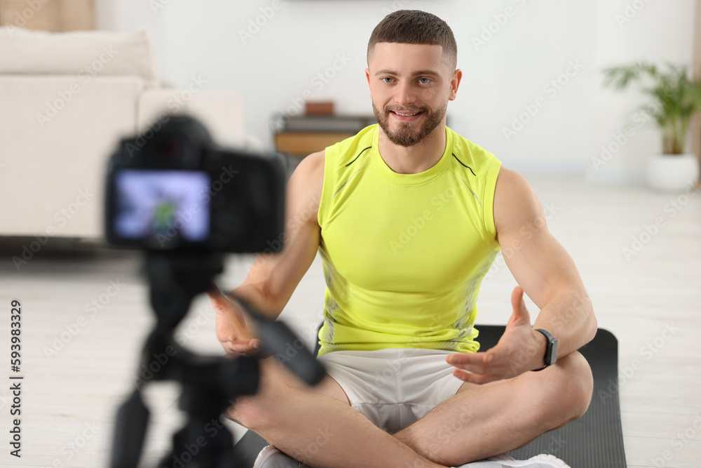 Obraz premium Trainer recording fitness lesson on camera at home