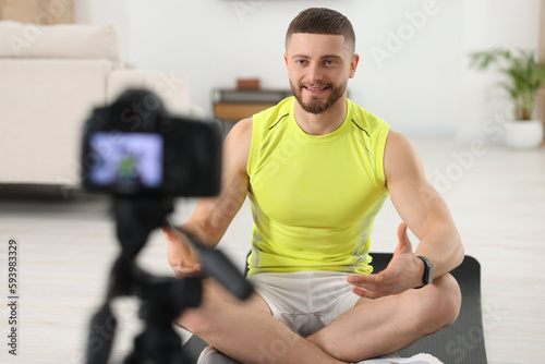 Trainer recording fitness lesson on camera at home
