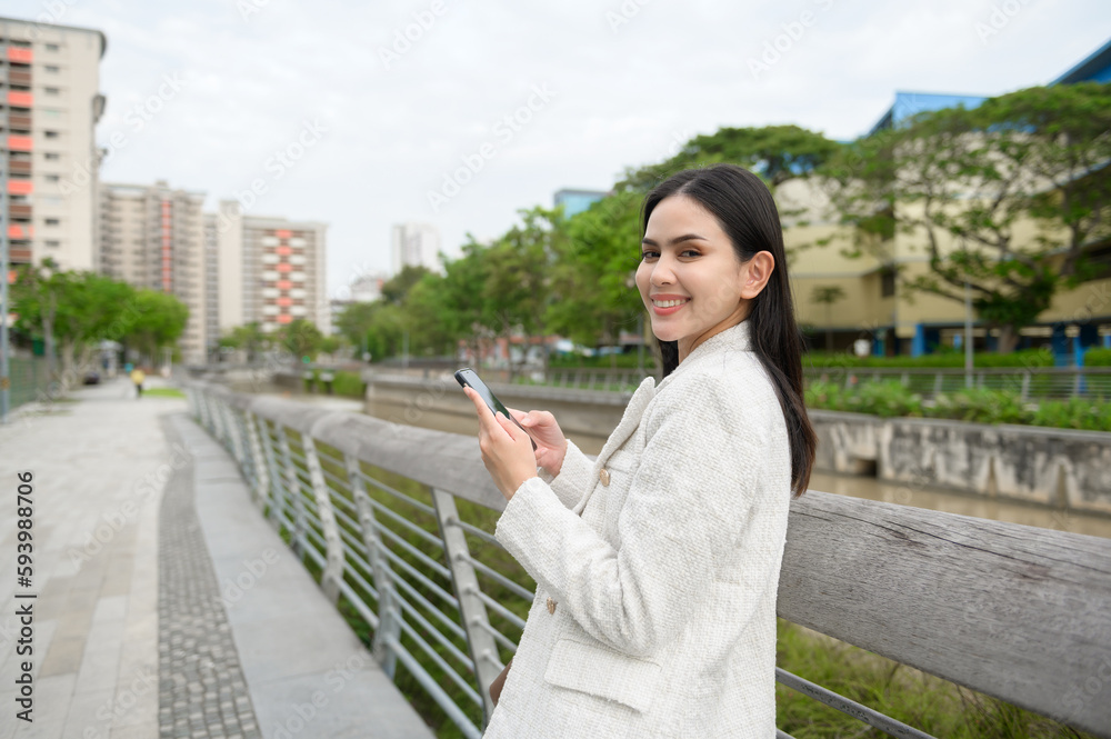 Fototapeta premium A young businesswoman is working in modern city downtown of Singapore