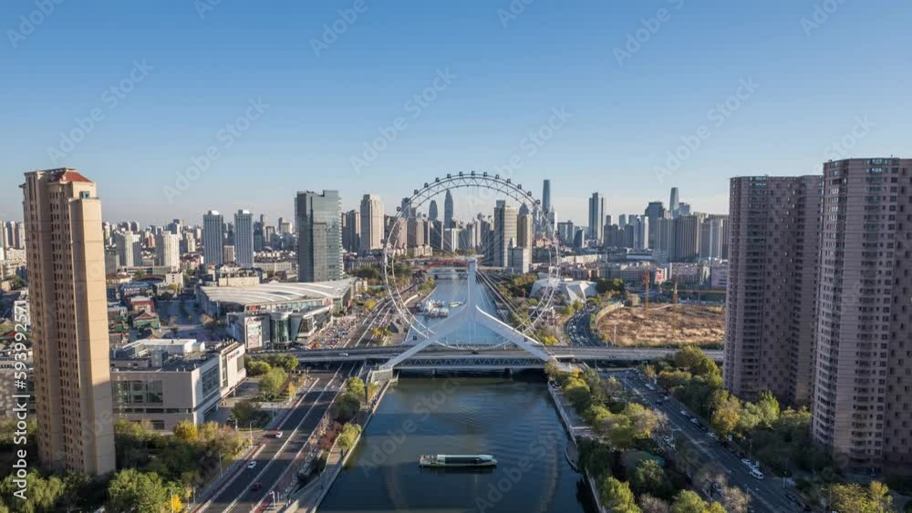 Drone hyper lapse of a river between skyscrapers and a huge Ferris wheel with bridge over the water