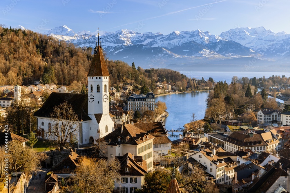 Scenic view of traditional buildings surrounding the tranquil Thun lake in Switzerland in autumn