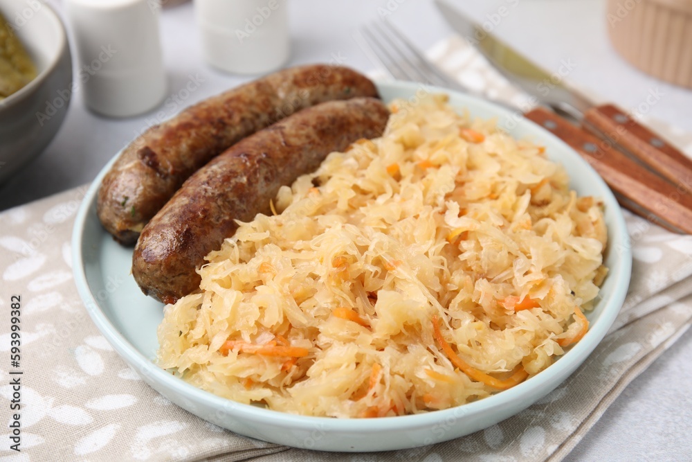 Plate with sauerkraut and sausages on table, closeup Plate with sauerkraut and sausages on table, closeup