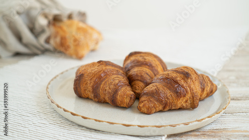 Delicious croissants and an artisanal ciabatta in an eco-friendly linen bread bag, arranged on a table with a lovely tablecloth.