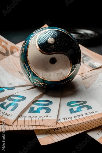Vertical shot of a yin-yang Chinese symbol on 50 euro banknotes.