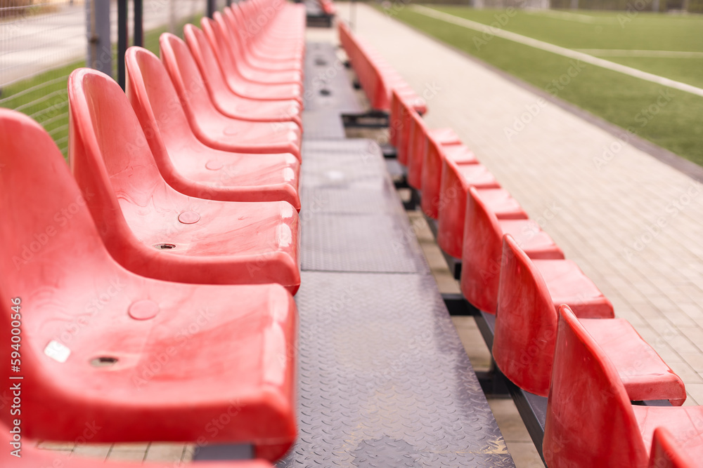 Empty red seats in football stadium.