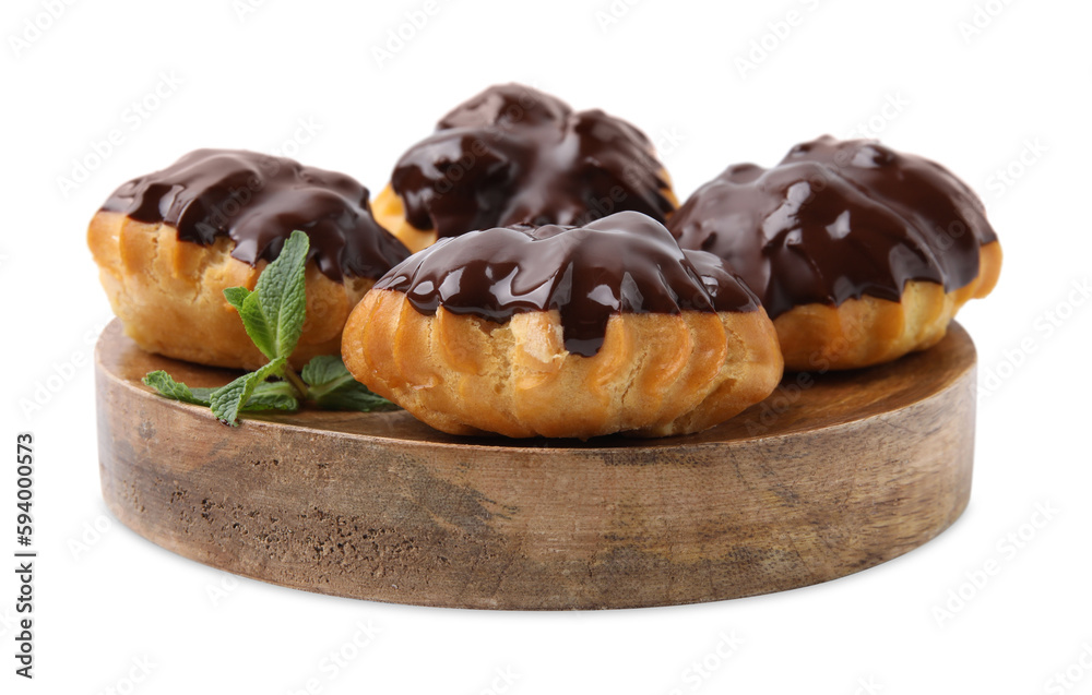 Delicious profiteroles with chocolate spread and mint isolated on white Delicious profiteroles with chocolate spread and mint isolated on white