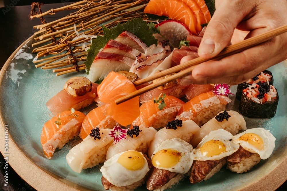 Person holding a sushi with chopsticks