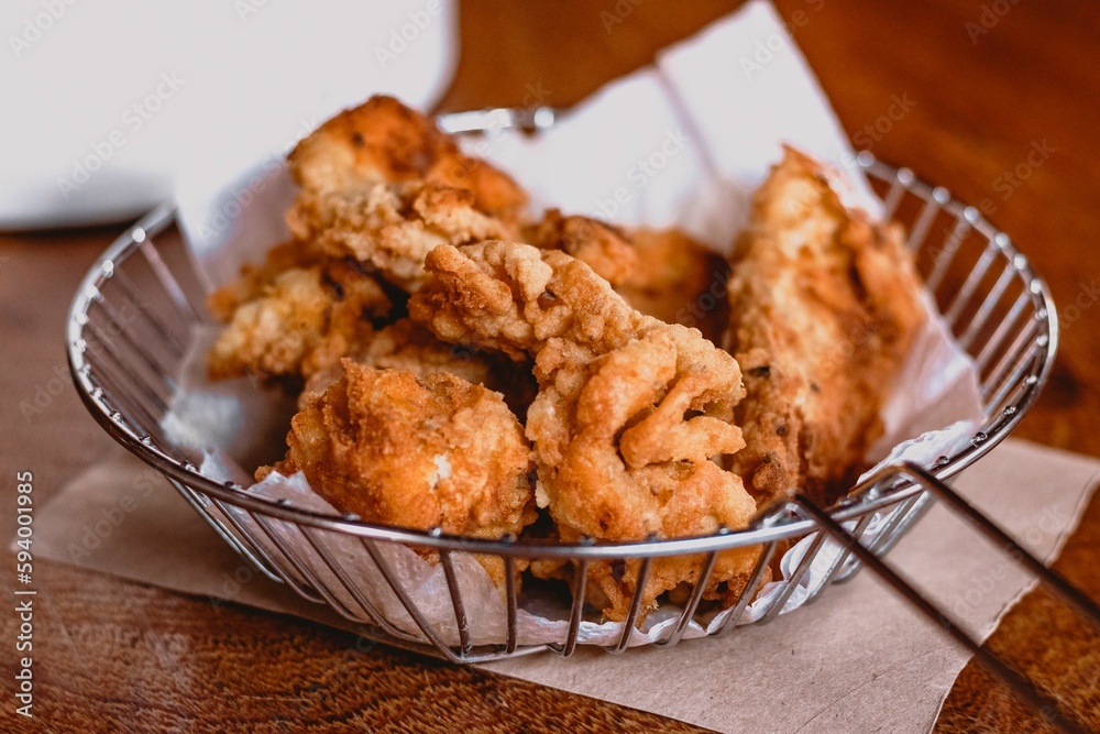 there is a basket full of fried food on the table there is a basket full of fried food on the table