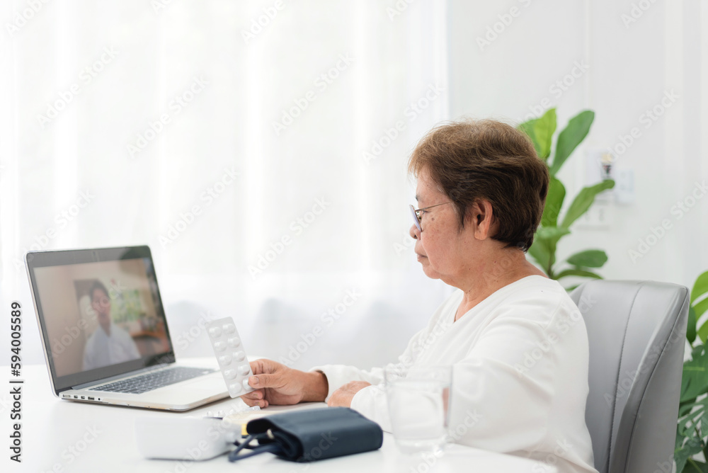 senior asian woman Meeting with a doctor via video call Using laptop from home, telemedicine and home healthcare. senior asian woman Meeting with a doctor via video call Using laptop from home, telemedicine and home healthcare.