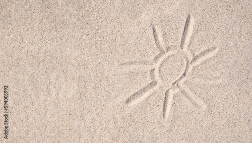 Sand background. Simple image of sun drawn on sand. Sandy beach. Blank negative space for copy.