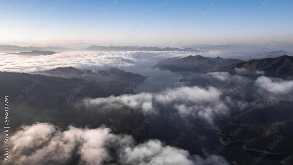 Drone view over moving mist above a fjord between mountains Drone view over moving mist above a fjord between mountains