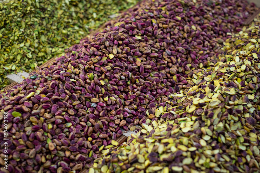 Obraz premium Piles of pistachio nuts for sale on food market