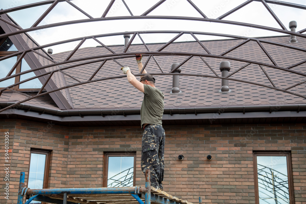 The worker installs the metal on the canopy.