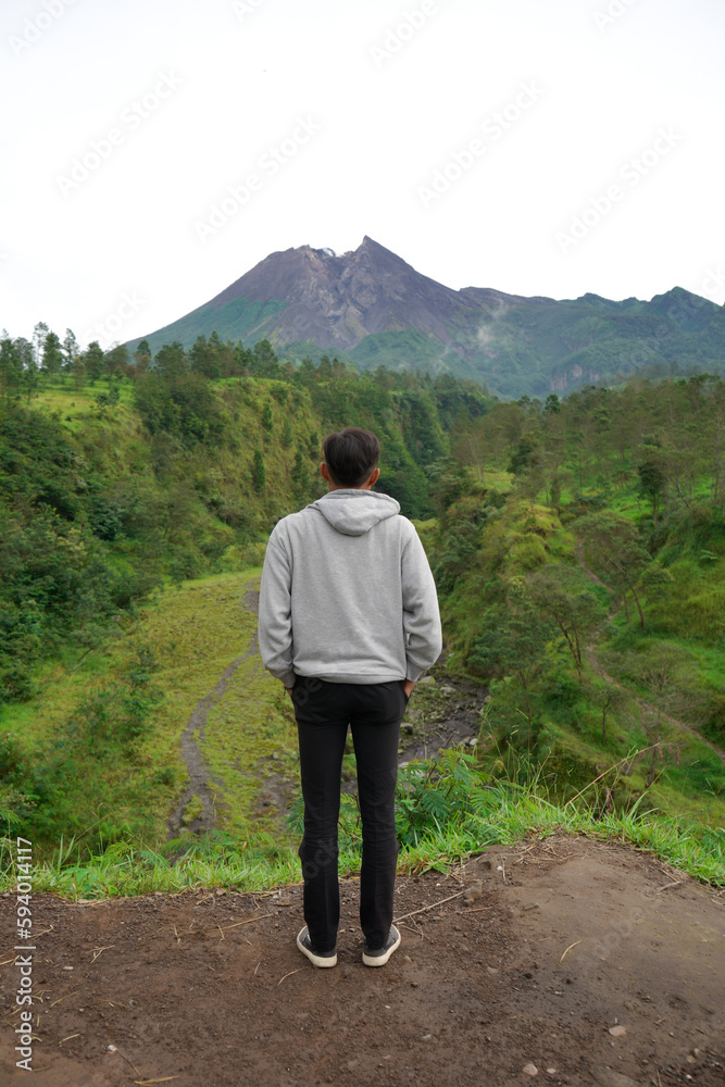 a man is enjoying the beautiful view of the volcano in the morning