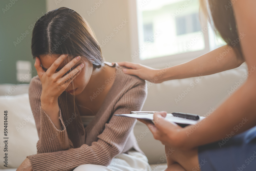 Psychology, sad asian young woman, girl cover face with hand, consulting with psychologist, psychiatrist while patient counseling mental with doctor woman taking notes at clinic. Encouraging, therapy. Psychology, sad asian young woman, girl cover face with hand, consulting with psychologist, psychiatrist while patient counseling mental with doctor woman taking notes at clinic. Encouraging, therapy.