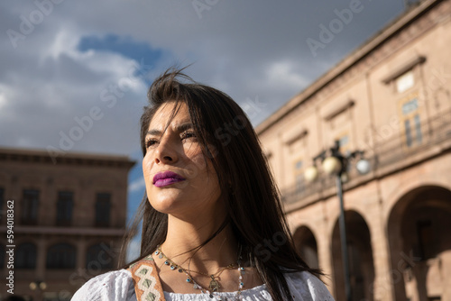 close up portrait of latin woman looking to the side in a cityscape at sunset