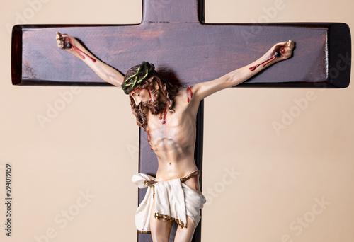 Wooden crucifix standing on brown background