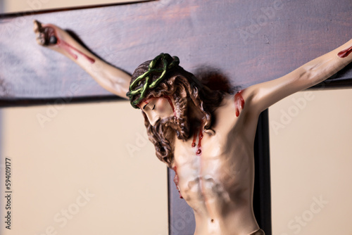Wooden crucifix standing on brown background