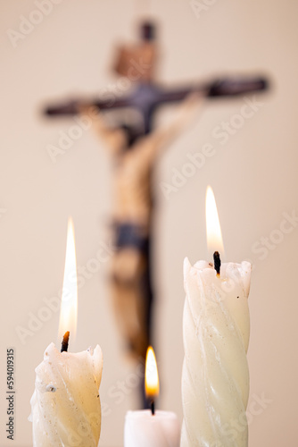 Candles and wooden crucifix on brown background