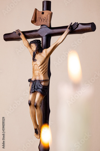 Candles and wooden crucifix on brown background