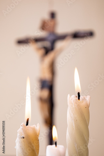 Candles and wooden crucifix on brown background
