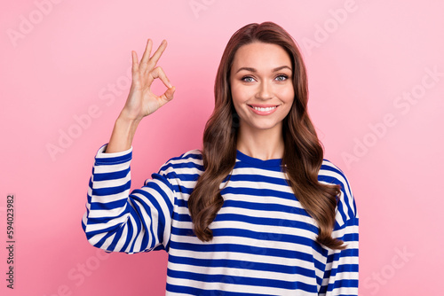 Photo of charming girl wear striped shirt sailor outfit enjoy her favorite job in sea swimming okey sign isolated on pink color background
