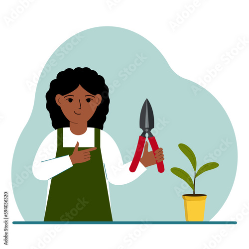 A gardener is a girl in working clothes, he has a pruner in his hand.