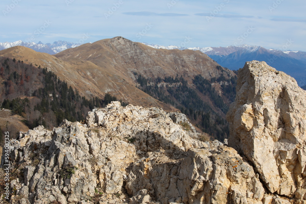 Landscape of a rocky mountain top with a row of peaks under a blue sky