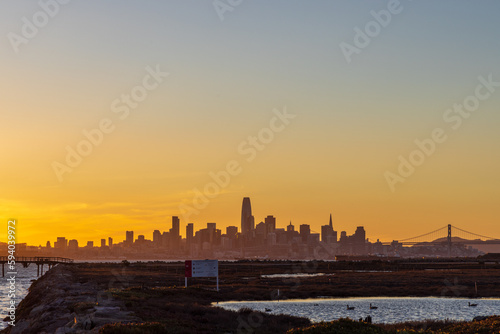 A view of the city of San Francisco from across the bay at sunset with a silhouette of the cityscape