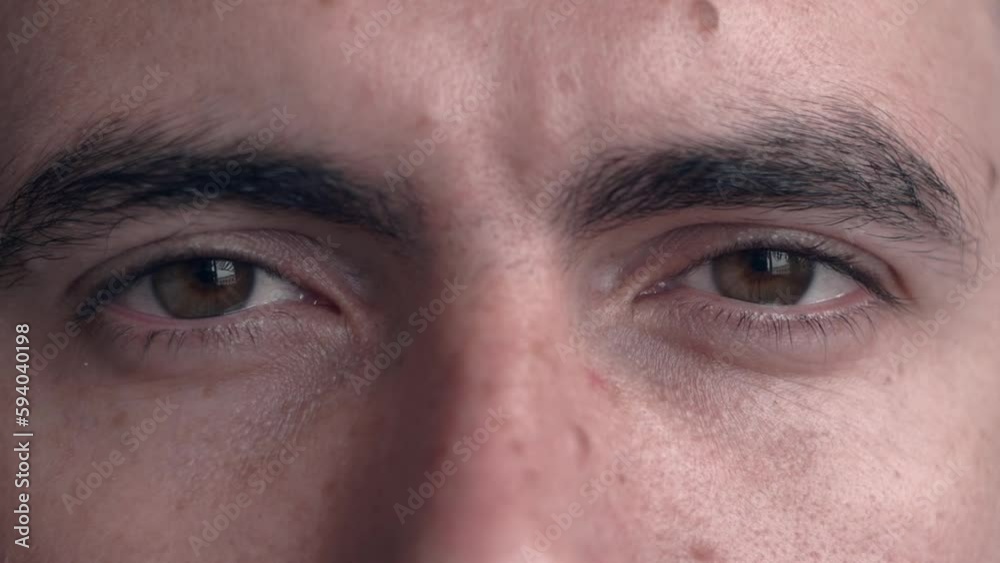 Extreme close up opening beautiful brown eyes of young man slow motion. Facial expressions, concept of emotions