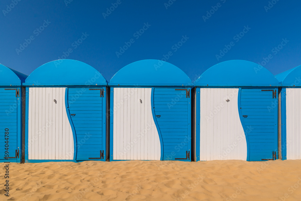 Scenic view of colored beach cabins at the beach in Dunkirk, France against blue summer sky