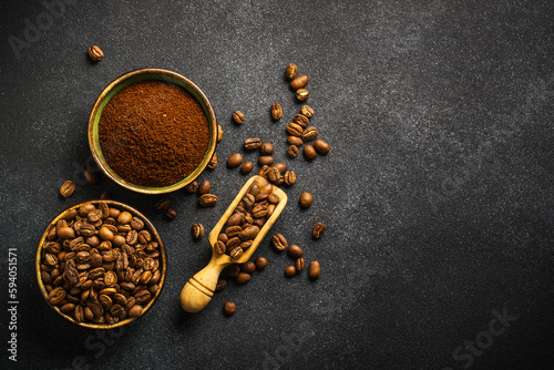 Roasted coffee beans and ground coffee in bowls at dark background. Top view image with copy space.