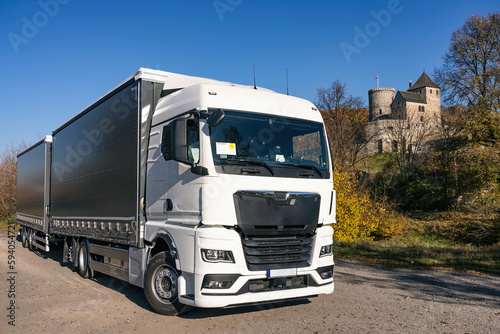 Truck on the background of the castle. Car transport . Truck with semi-trailer in gray color.  Truck photo for calendar