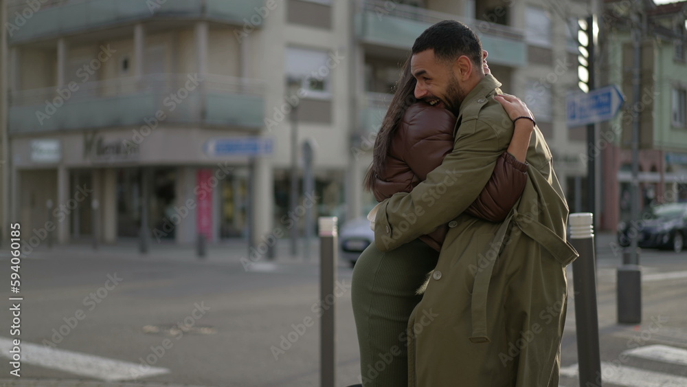 Fototapeta premium Two happy people embracing each other outside in city street. A joyful couple hug. Male and Female friendship. Authentic love and care