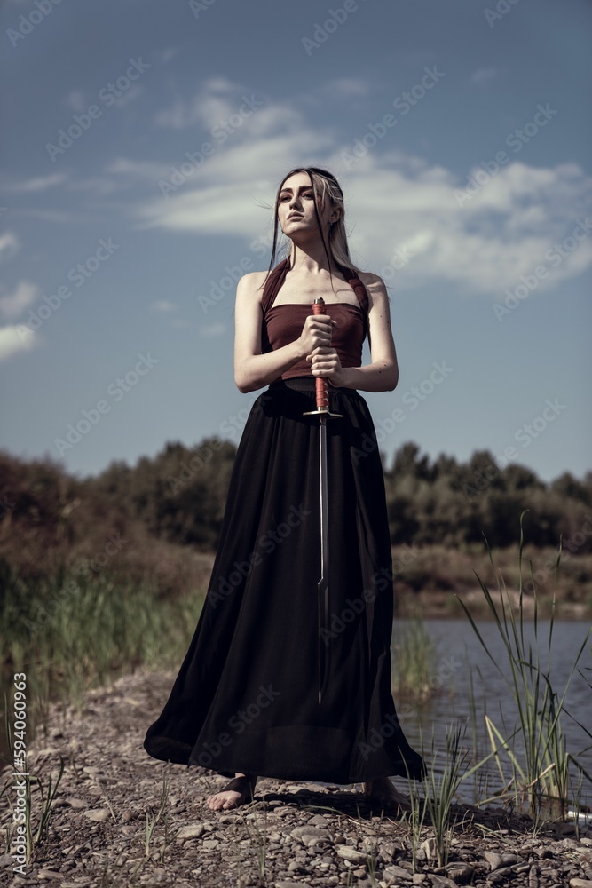 Caucasian woman holding knife and standing near lake