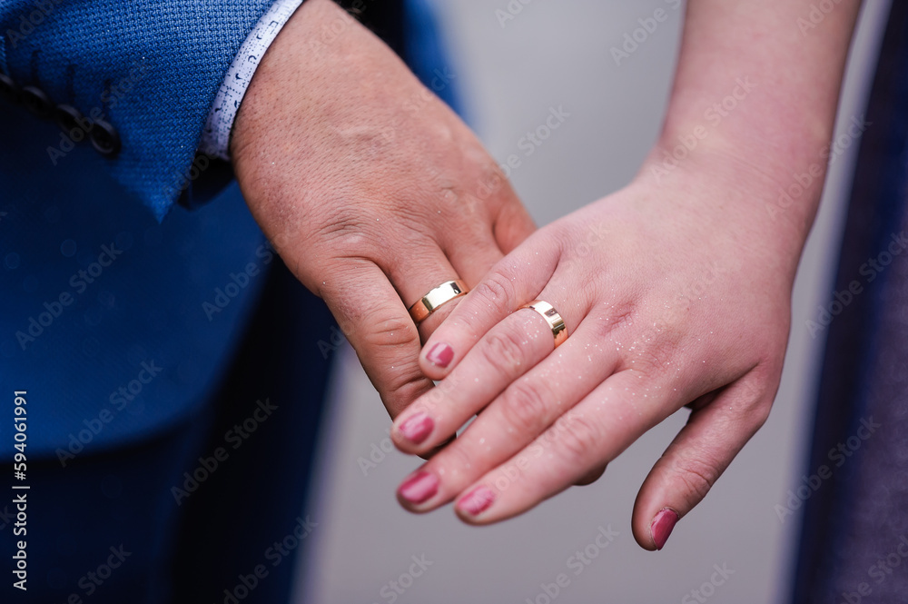 Wedding gold rings on the hands of the newlyweds. Gold rings on the hand of a man and a woman Wedding gold rings on the hands of the newlyweds. Gold rings on the hand of a man and a woman