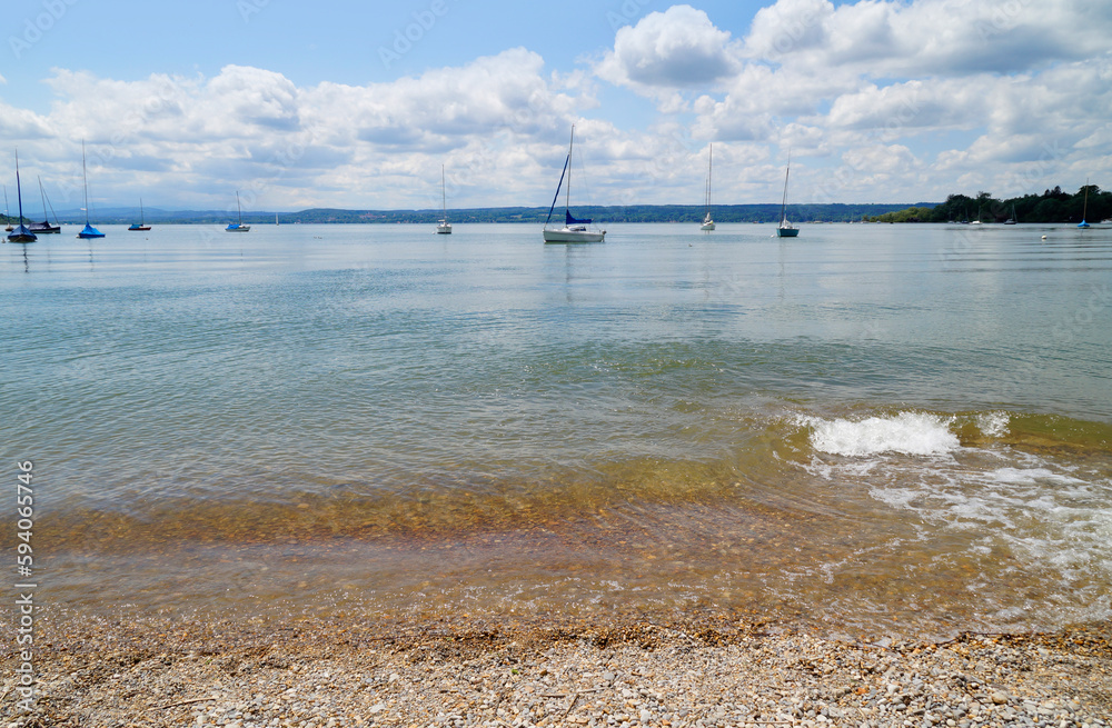 a romantic view with sailing boats on scenic and vast lake Ammersee on a sunny day in April Herrsching, Bavaria, Germany	