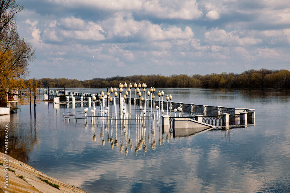 Fototapeta premium Landscape with river, forest and embankment in the city in spring. Flood and flood of river water in spring. Rivers of Belarus. the city of Gomel. Europe.